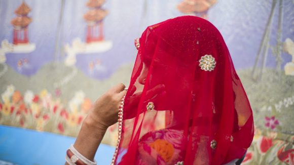 Manju, an Indian woman with a disability, sits and thinks.