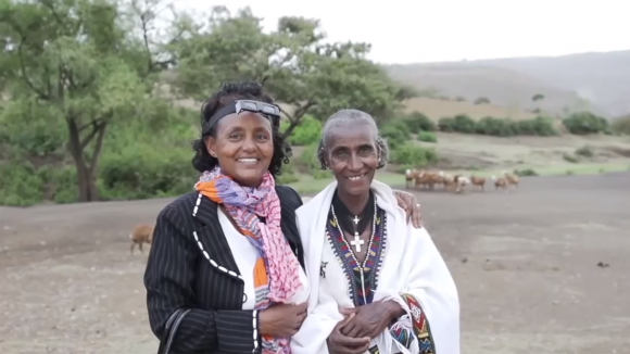 A still from Sightsavers' Global Trachoma Mapping Project video, showing an eye health worker with her arm round a local villager.