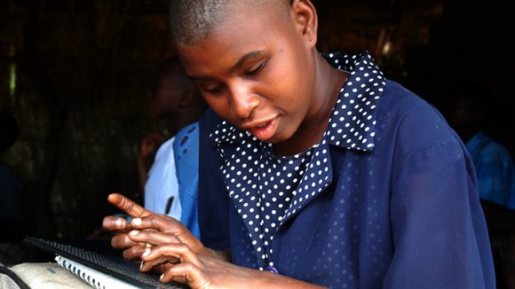 A girl in class reading braille.