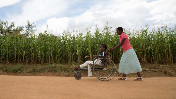 Woman pushing child in wheelchair