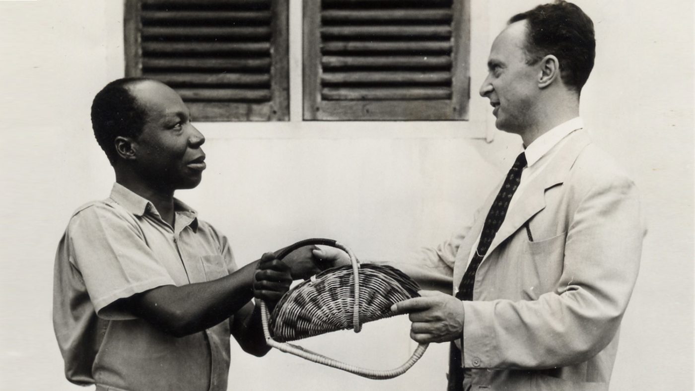 Sir John Wilson meets a local man and is presented with a gift during a visit to Ghana.