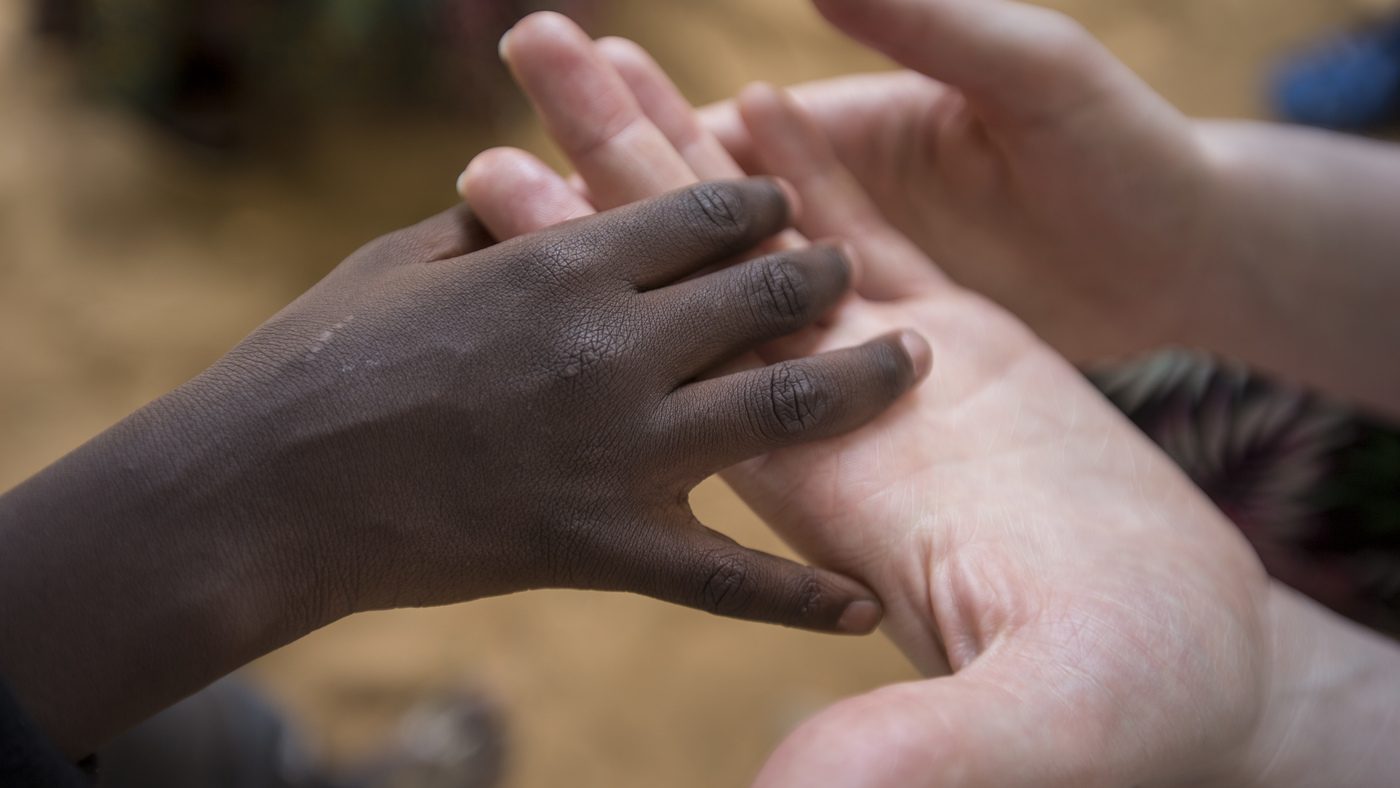 Adult and child interlinking hands