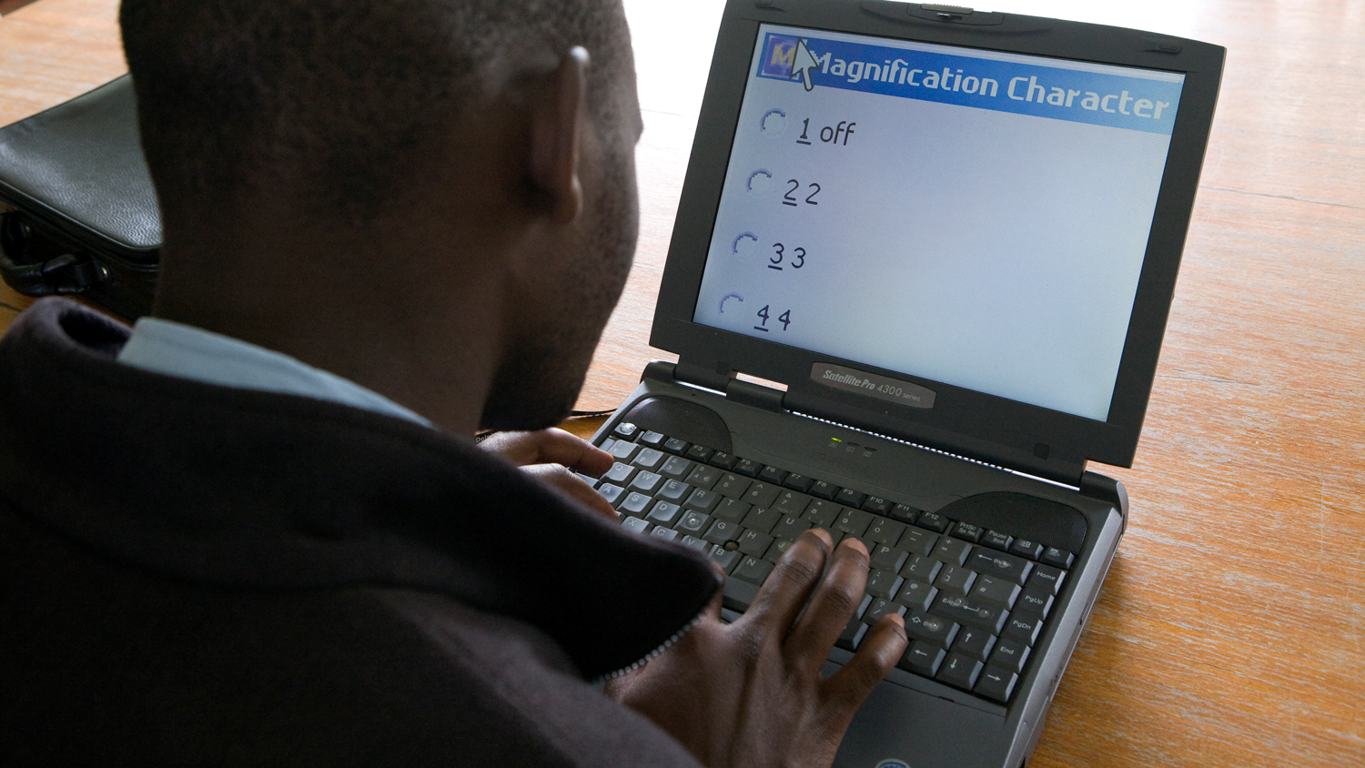 Man using a computer's built-in screen magnification options