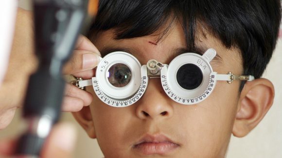 A boy in Pakistan wears special spectacles during an eye test.