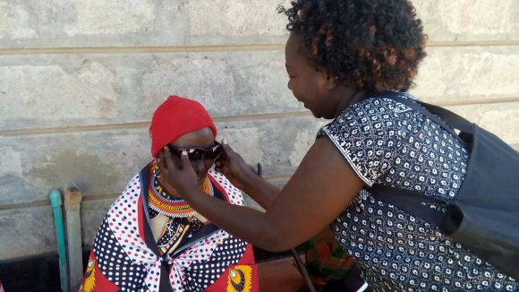 A woman is given sunglasses following cataract surgery in Kenya.