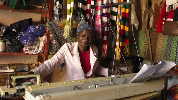 Sylvia sat down, knitting on a machine.