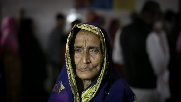 An older woman stands alone in Bangladesh.