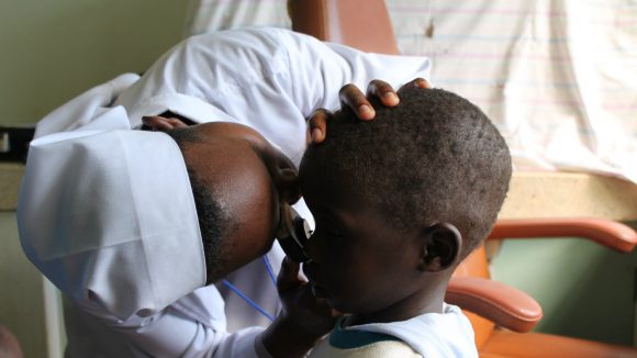 A child's eyes are examined by a nurse.
