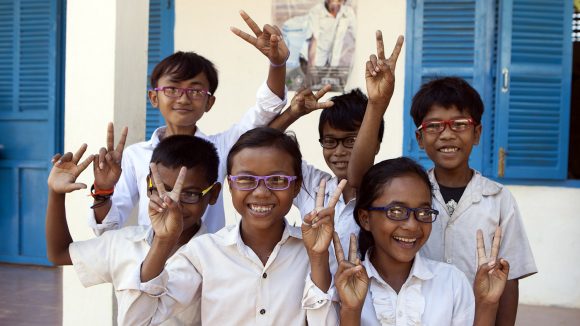 Students from Wat Run primary school in Cambodia smile and laugh while wearing their new glasses.