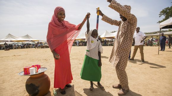 Seven-year-old Dorcas celebrates with the villagers after receiving her treatment for NTDs.