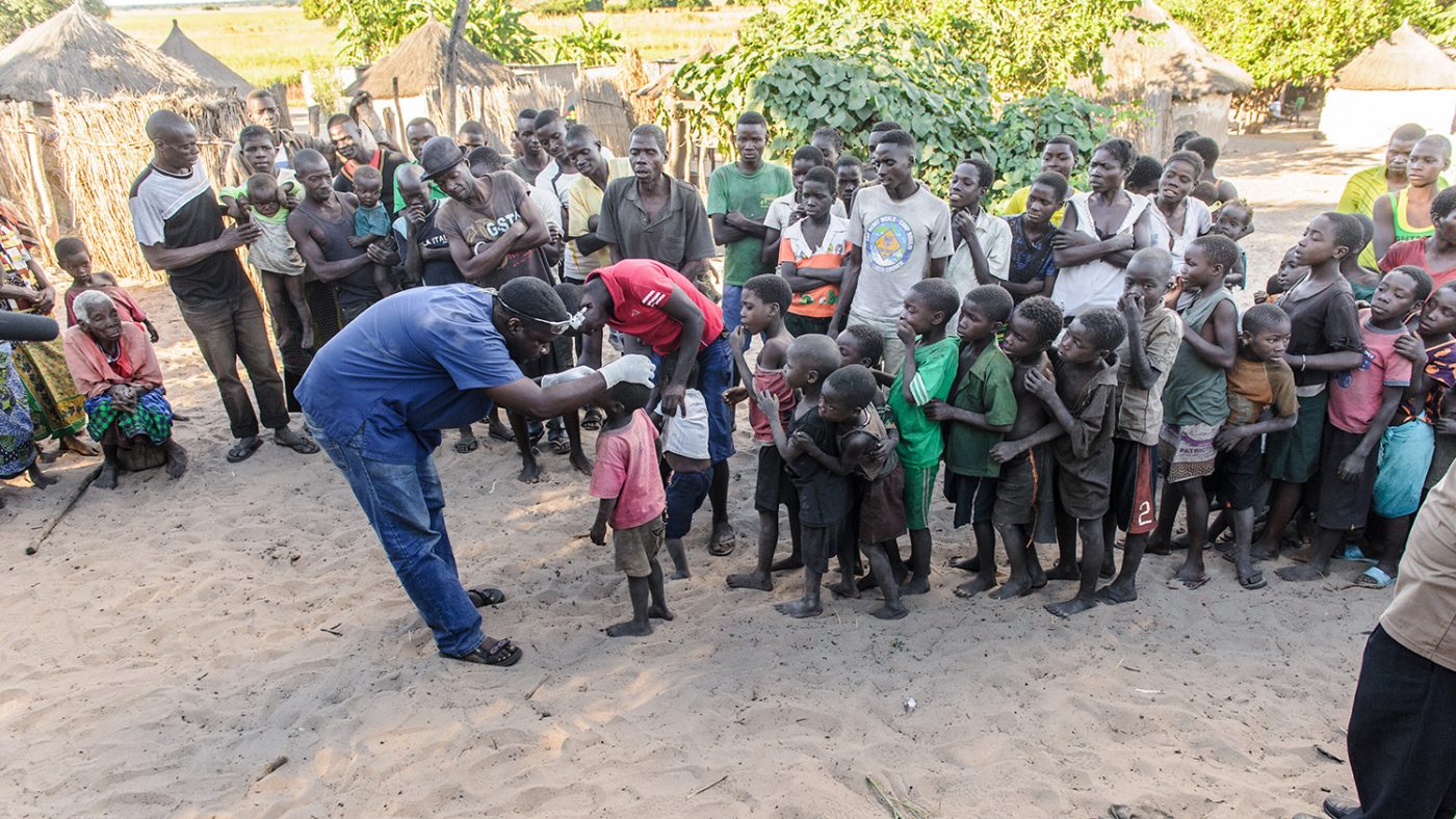 Dr Ndalela is shown screening a queue of young children for trachoma, in Zambia.