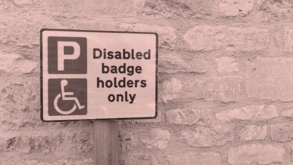 A parking sign with the words 'Disabled badge holders only'.