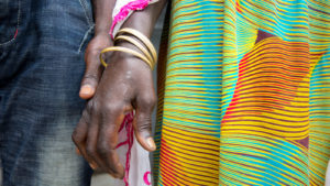 A close up of two women holding hands.