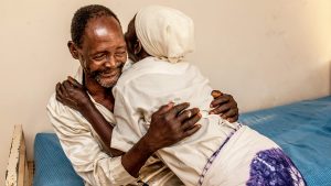 Winesi March and his wife embrace at the joy of his sight being restored.