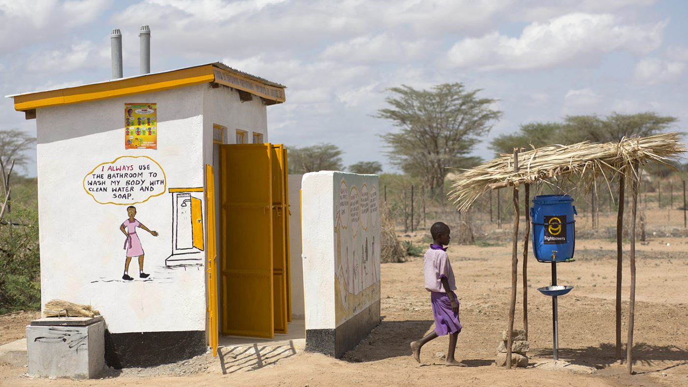 A boy washes his hands after going to the toilet.