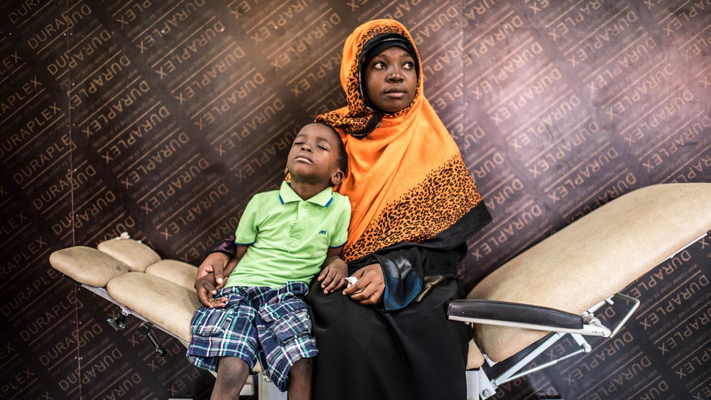 Fahad sits with his mother in a hospital waiting room.