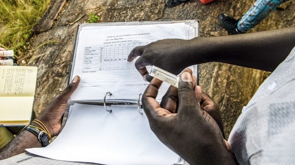 A volunteer records stats on a chart.
