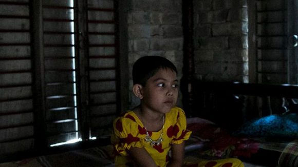 Muslima sits alone in the dark.