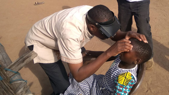 A volunteer in Cote d'Ivoire learns how to spot trachoma by examining a child's eyes.