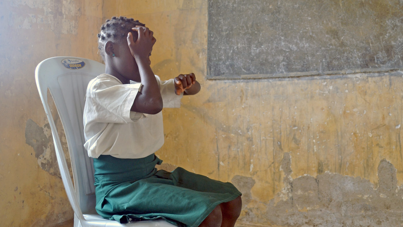 A student covers one eye during an eye test.