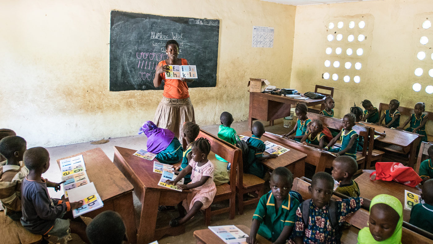 A teacher stands at the front of the class in Sierra Leone.