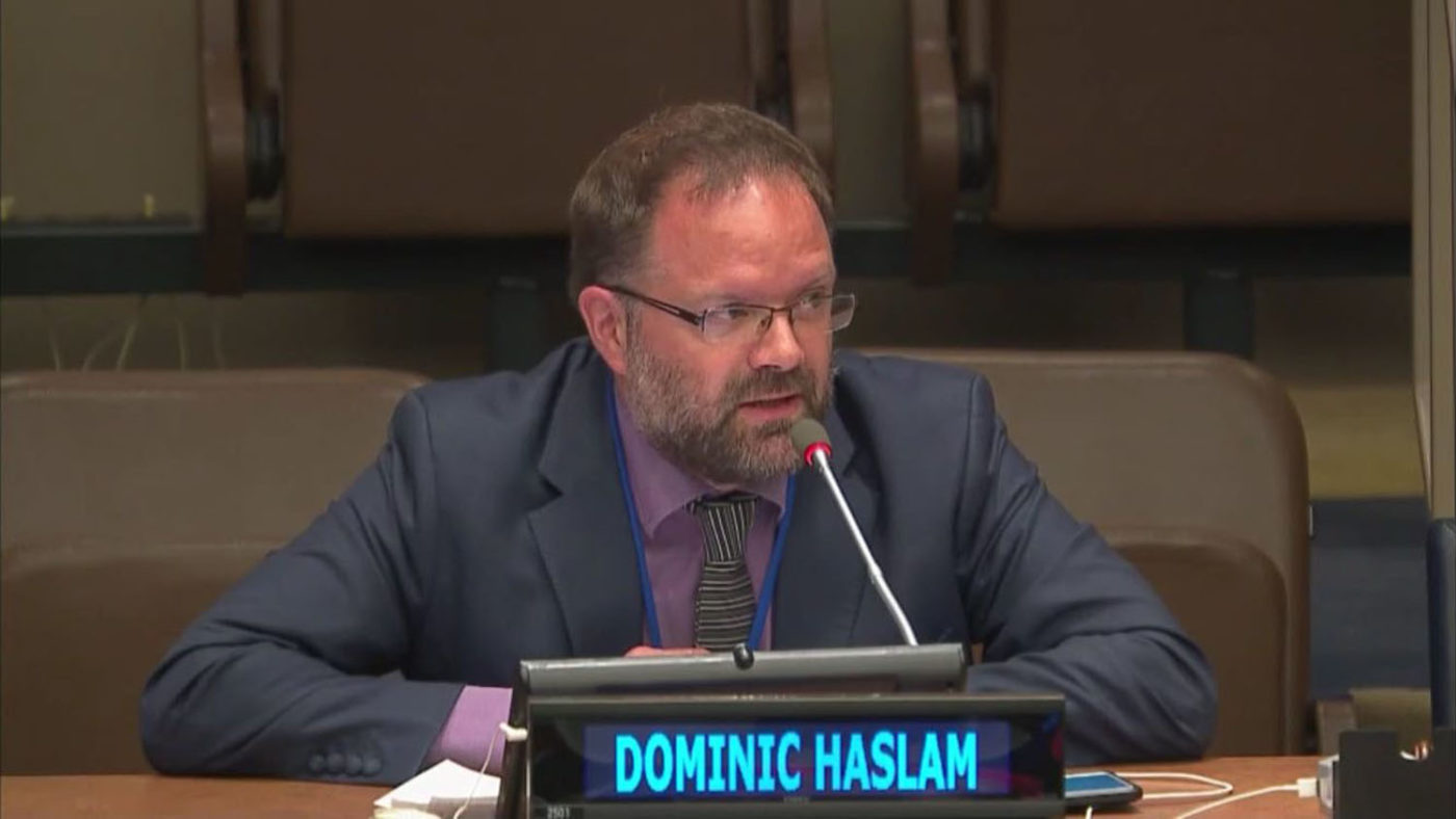 Dominic Haslam sat at a desk talking into a microphone