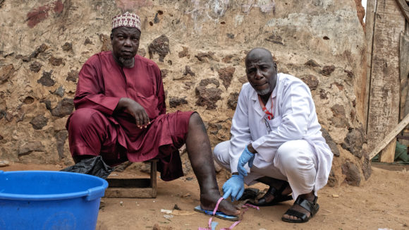 Muhammed, who has lymphatic filariasis, with health worker Suraji in Nigeria.