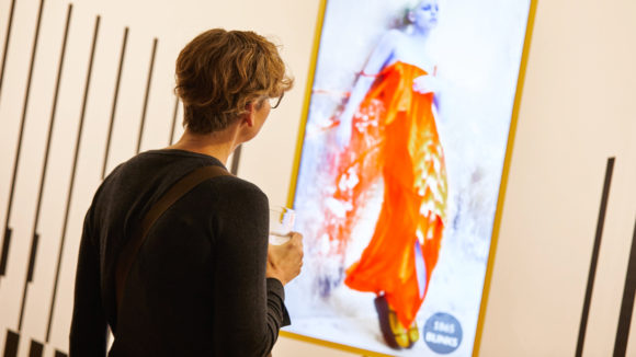 Lady looking at degrading image in art gallery