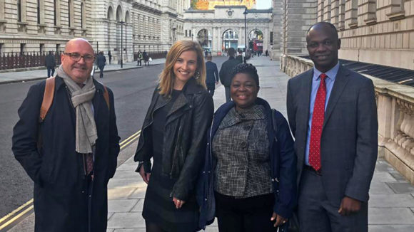 Four Sightsavers staff members smile at the camera.
