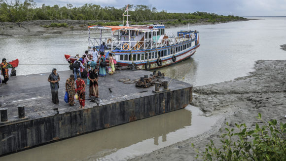 People getting off a boat at a dock.
