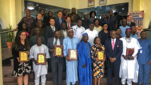 A large group of people stand with their awards for tackling river blindness in Nigeria.