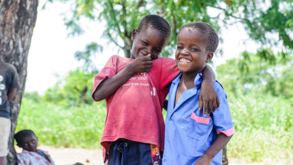 Two boys laughing outside.