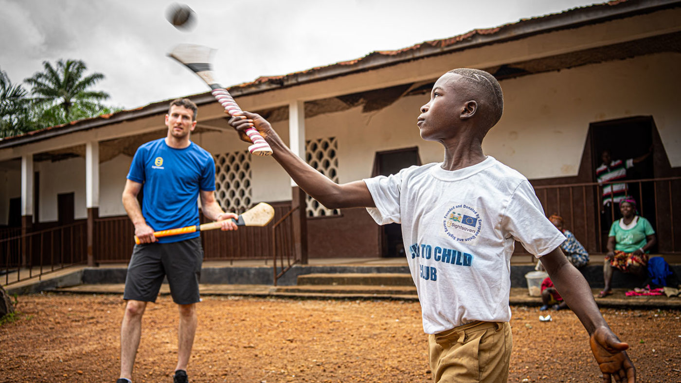 Abdul plays hurling outside his school.