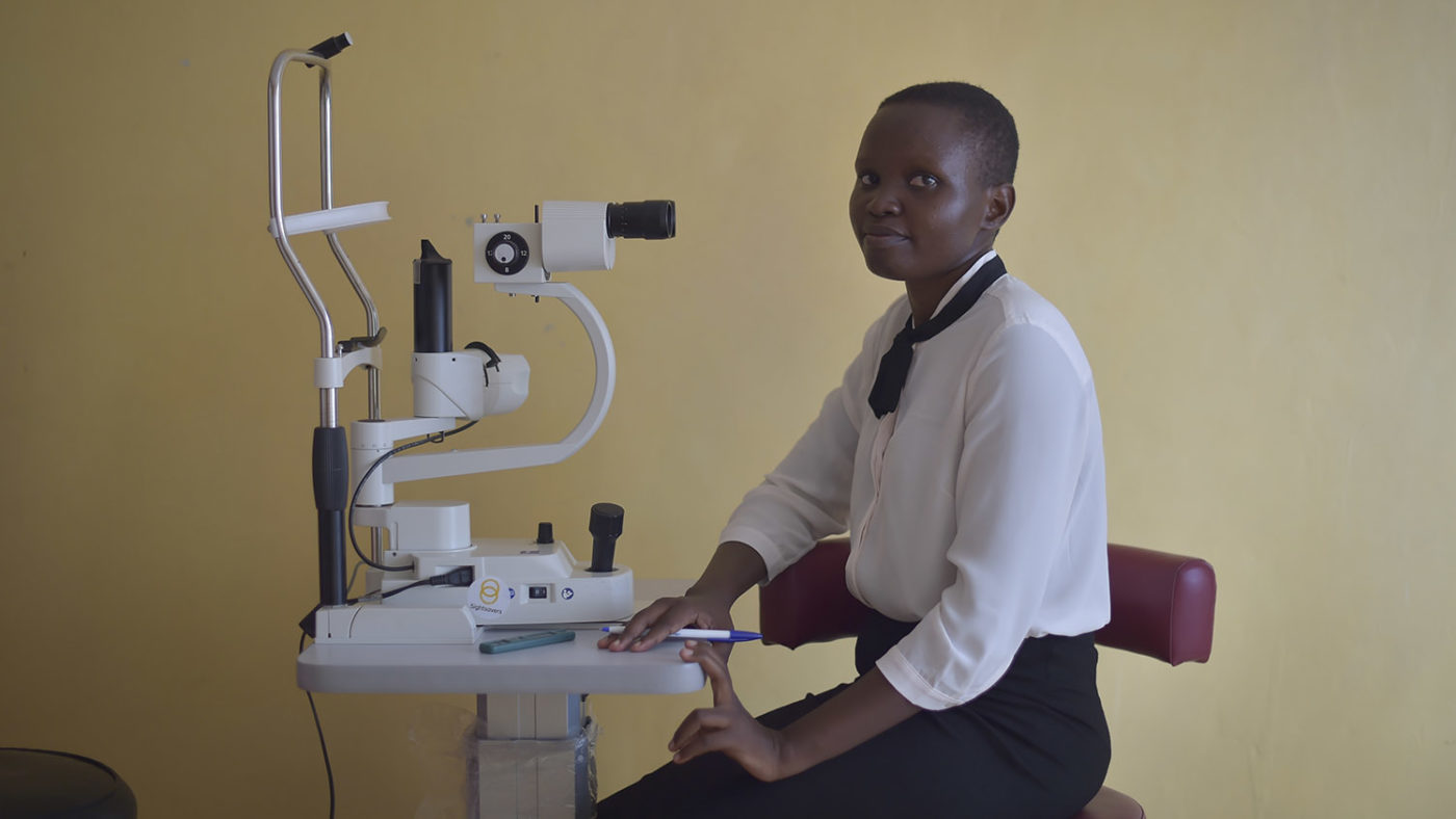 An optometrist sits with her equipment.