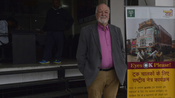Clive Jones stands next to a sign.