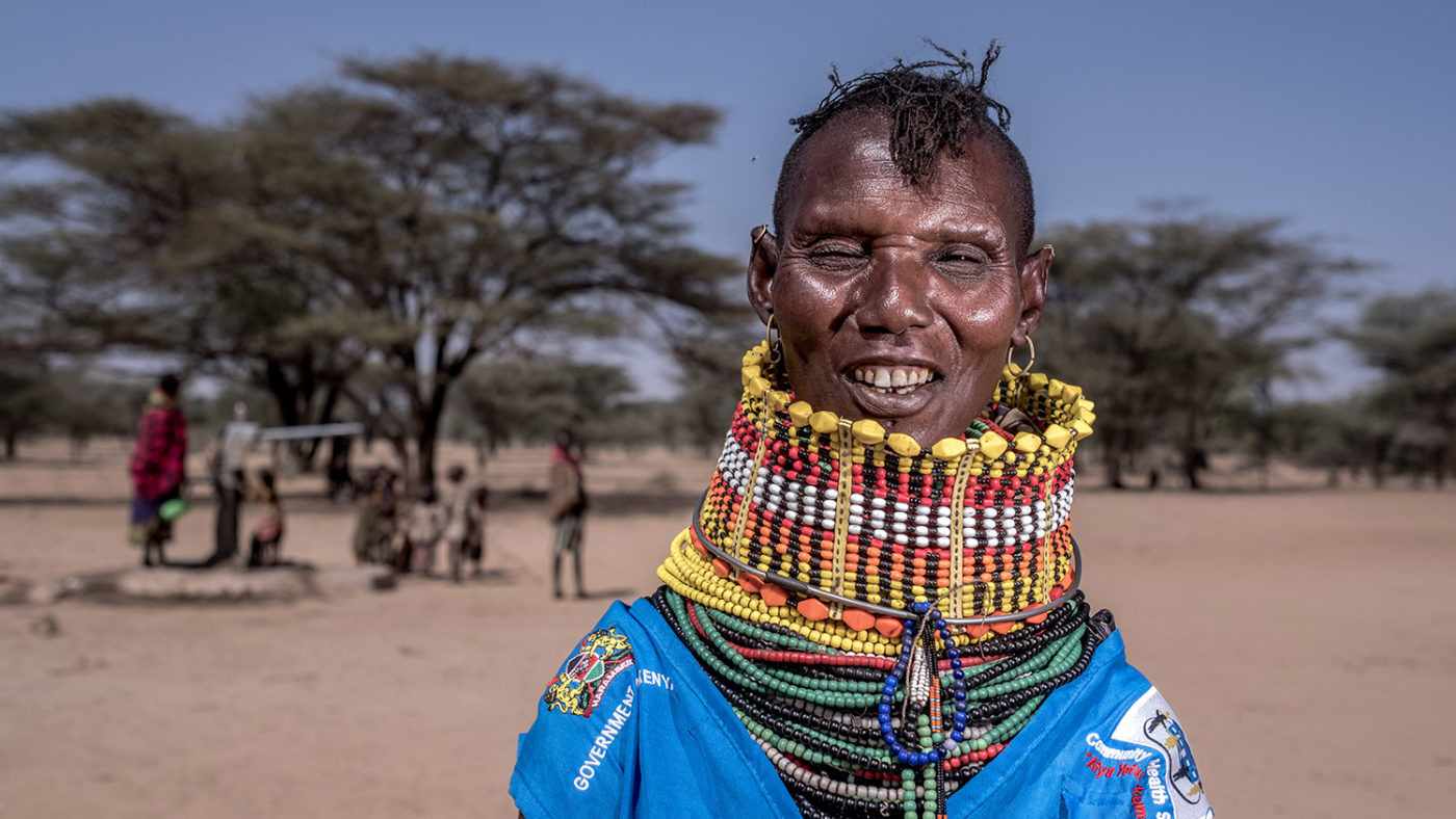 A woman in traditional clothes smiles.
