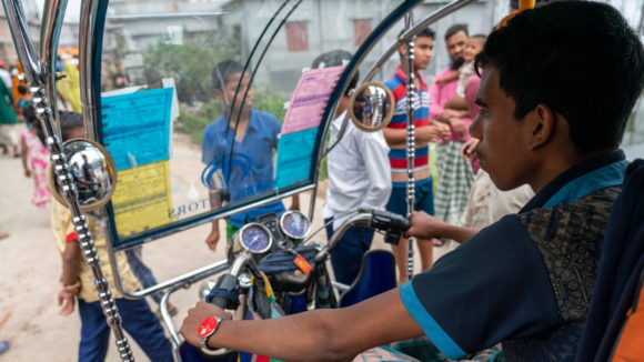 A man driving a tuk-tuk.