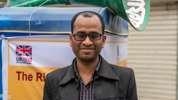 A man smiling with glasses on.