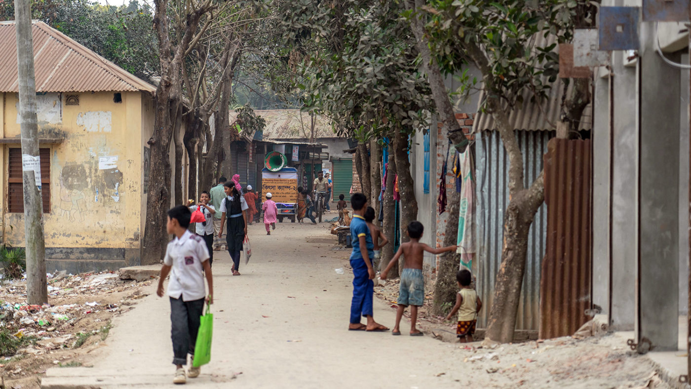 A miking tuk-tuk driving through a street in Bangladesh.