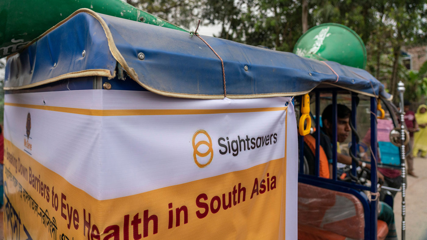 A miking tuk-tuk in Bangladesh with the Sightsavers logo on the side.