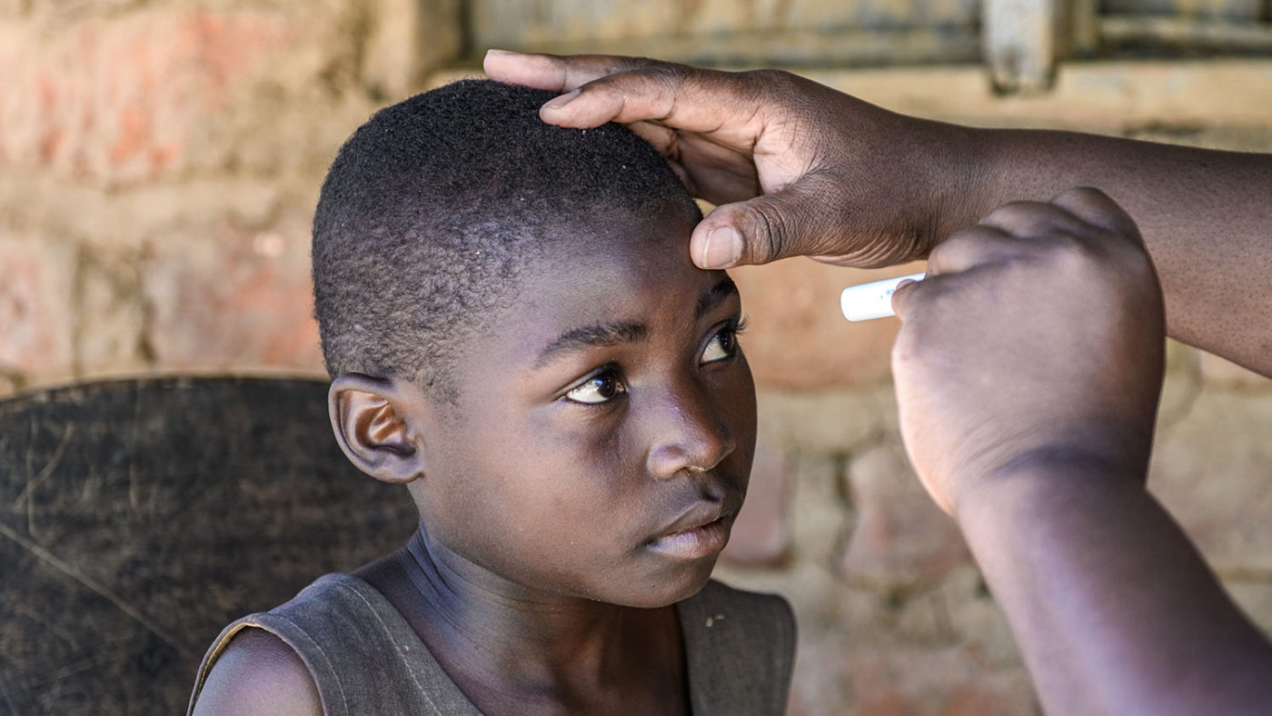 A Sightsavers-funded health worker checks Mary's eyes.