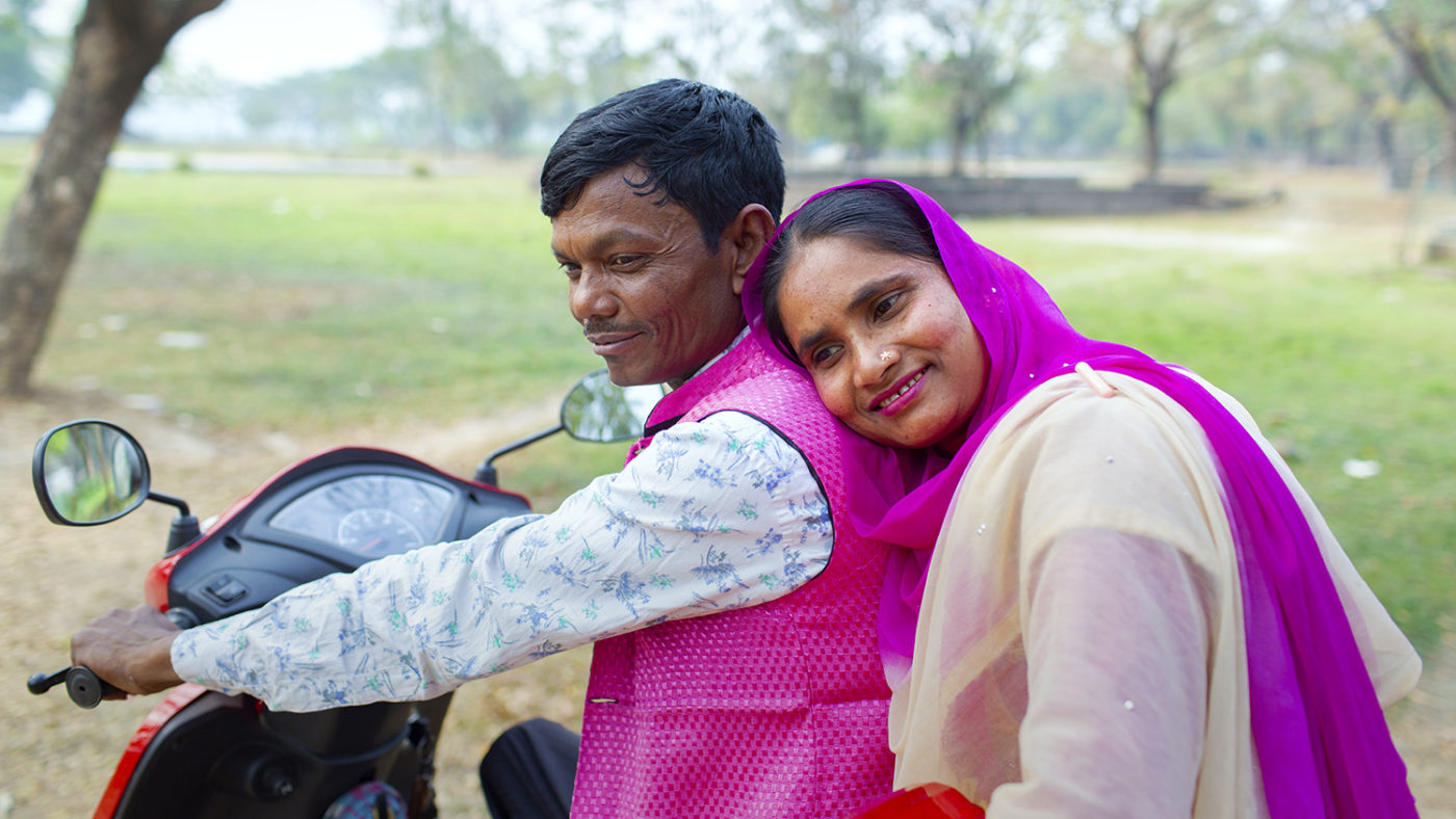 A woman rests her head on a man's shoulder.