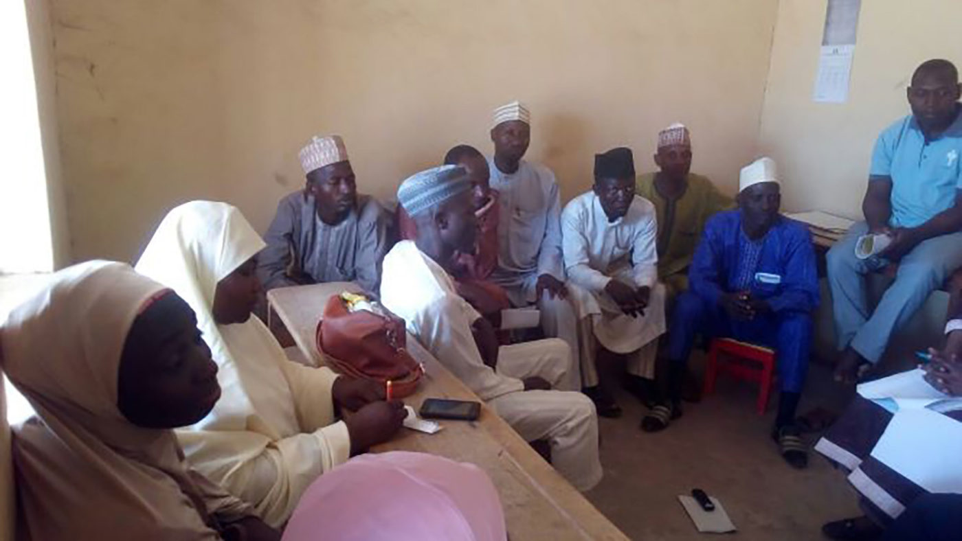 A group of men sit in a room.