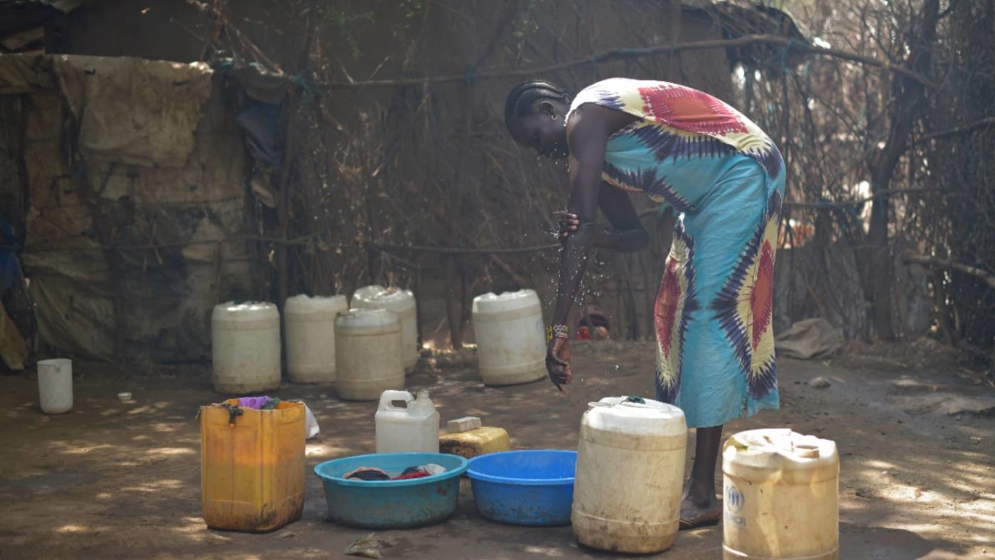 Rebecca washes some clothes outside her home.