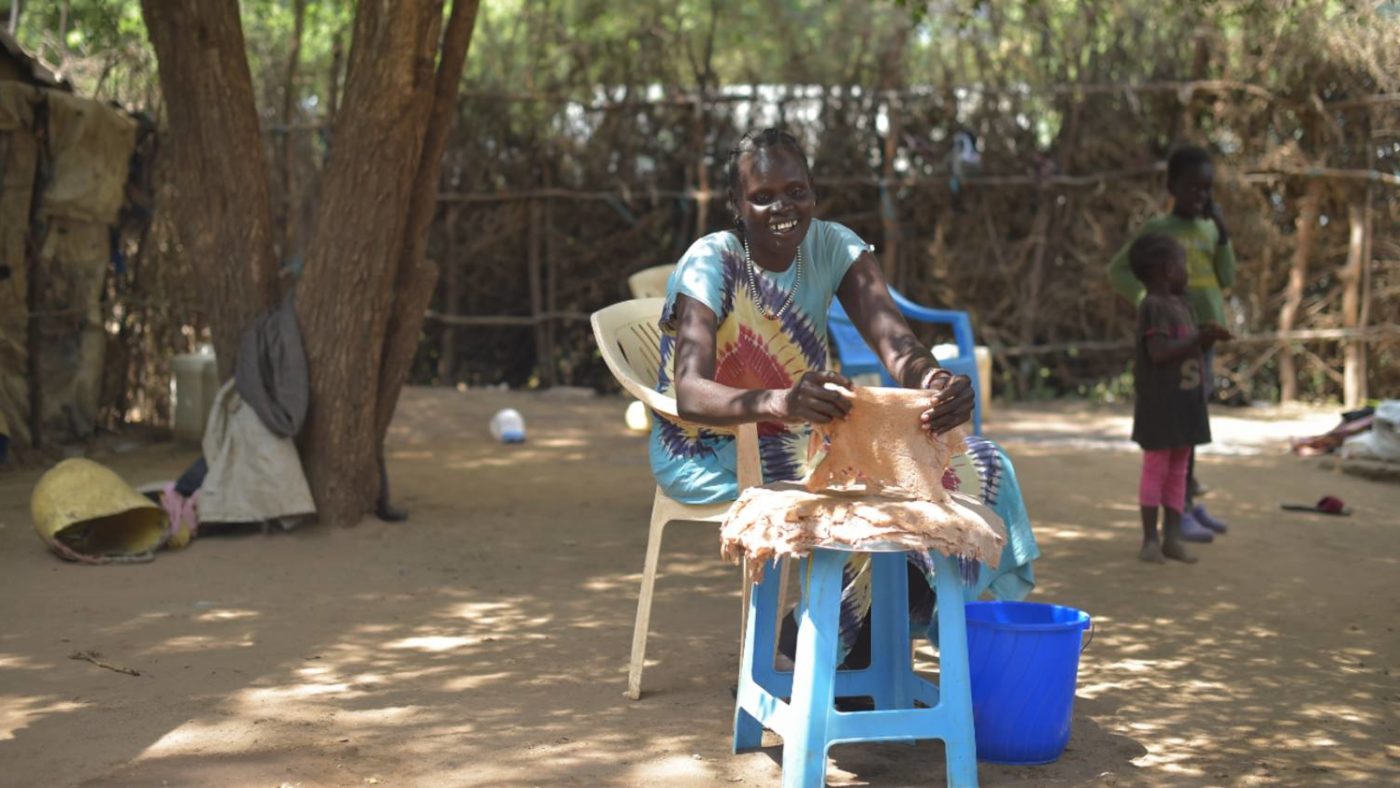 Rebecca weaves mats in her courtyard in Kenya.
