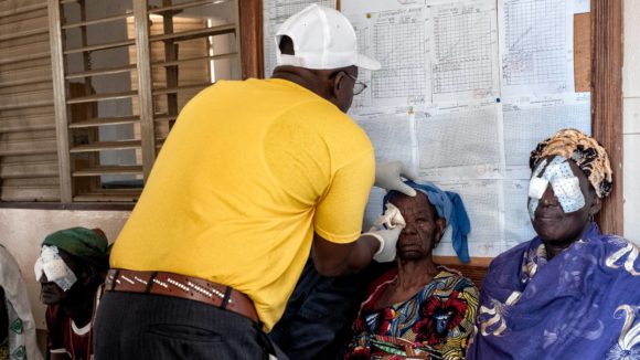A surgeon removes the bandages from a trachoma patients eyes.
