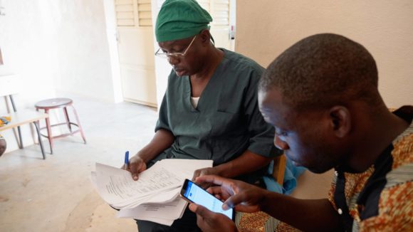 An assistant use a mobile app to input trachoma patient data from the surgeon.