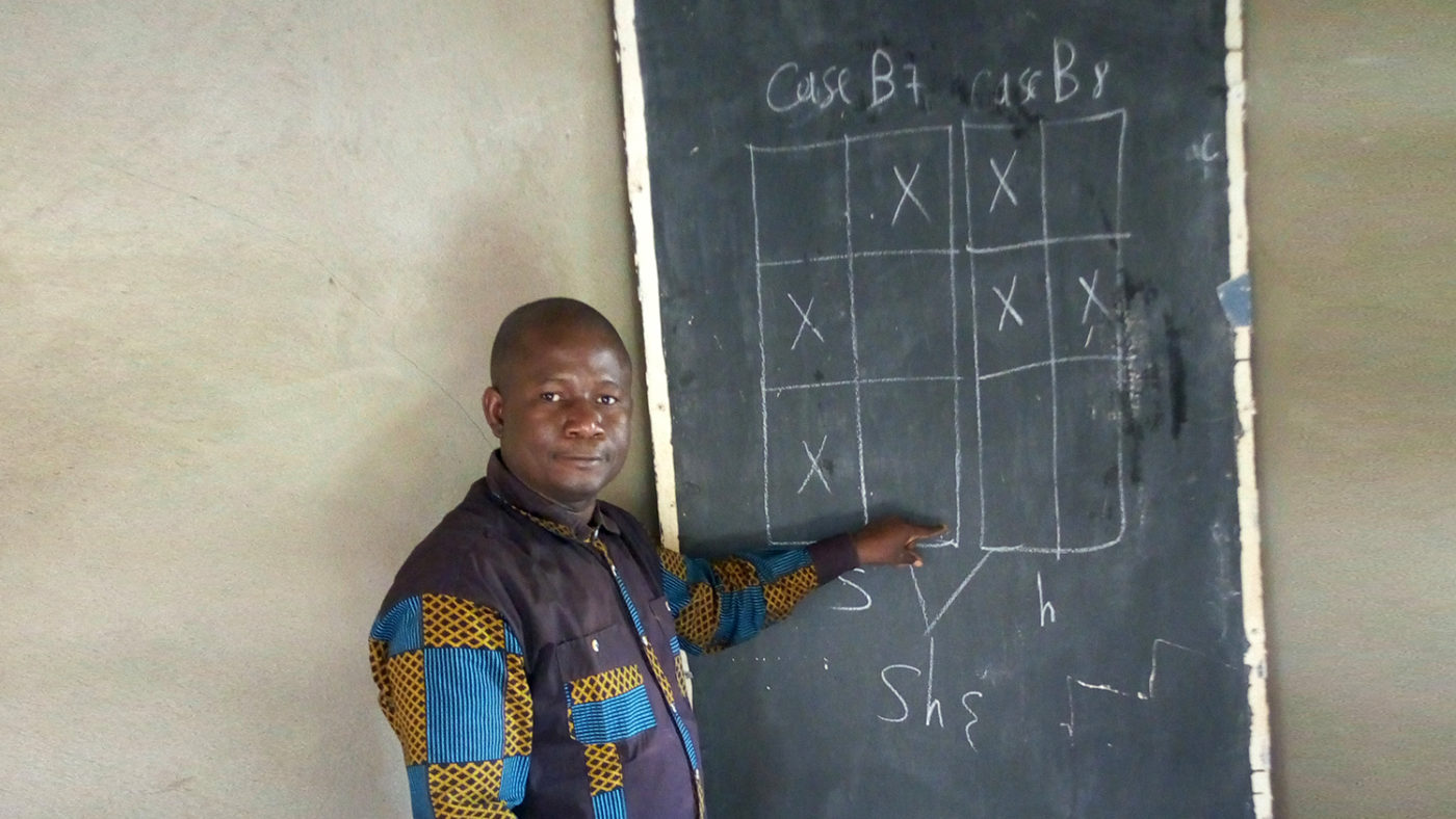 A man pointing to a blackboard.