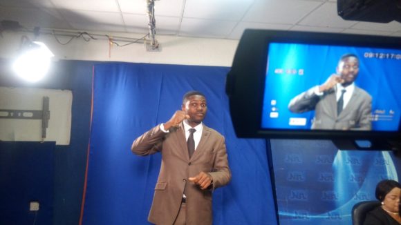 A sign language interpreter in a TV studio.