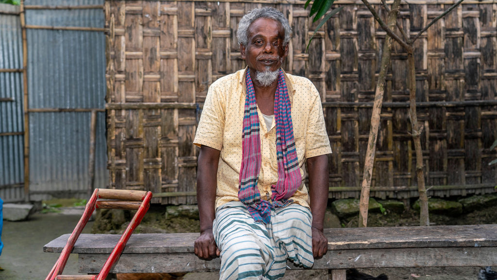 A man who is missing a leg, sitting outside.